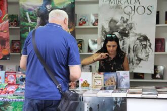 Un hombre ojea los libros de una vendedora de libros