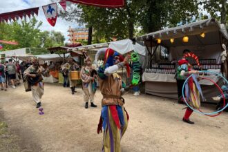 Varios personajes disfrazados como bufones pasean por las calles del Mercado Medieval tocando música y haciendo malabares.