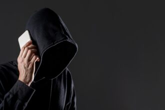 Un hombre encapuchado habla por el teléfono móvil