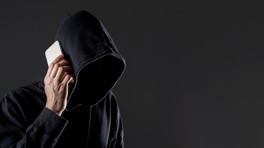 Un hombre encapuchado habla por el teléfono móvil