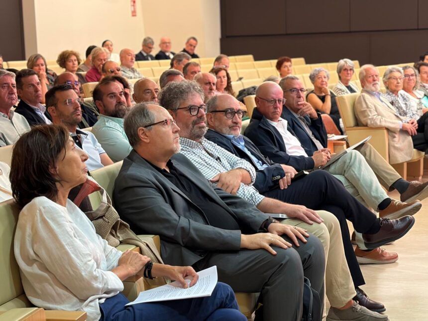 Personas sentadas en un auditorio mirando hacia el escenario