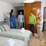 Varias personas charlan en una habitación de hotel durante la visita a las instalaciones