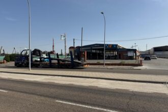 Nave de la inspección técnica de vehículos de Palencia, con varios coches esperando a ser atendidos y un camión portacoches aparcado fuera.