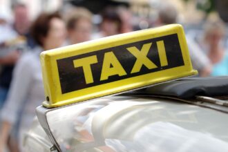 cartel colocado en el techo de un vehículo en el que se puede leer Taxi