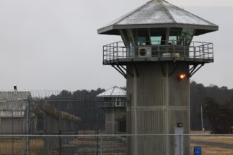 torre de vigilancia de cemento y alambra de espino en un centro penitenciario