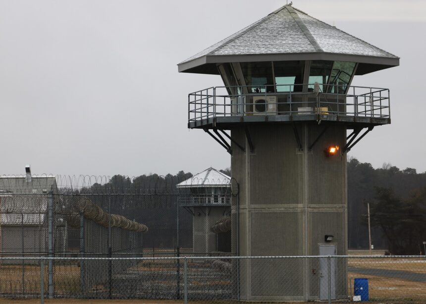 torre de vigilancia de cemento y alambra de espino en un centro penitenciario