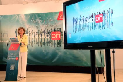 La consejera de Educación, María Pardo, habla desde un atril jutno a una pantalla de televisión del inicio del curso escolar.