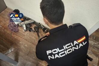 Un Policía Nacional observa varios objetos vinculados con la mecánica del automóvil depositados en el suelo.