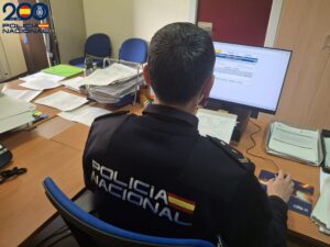 Un Policía Nacional frente a una pantalla de ordenador.