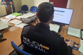 Un Policía Nacional frente a una pantalla de ordenador.