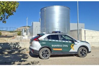 Vehículo de la Guardia Civil delante de una instalación industrial.