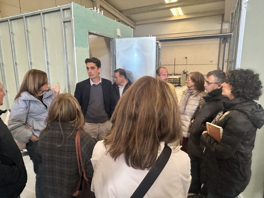 Varias personas escuchan lo que dice otra en la visita a una fábrica