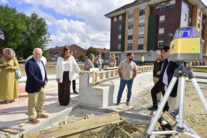 Varias personas contemplan la evolución de unas obras en una plaza