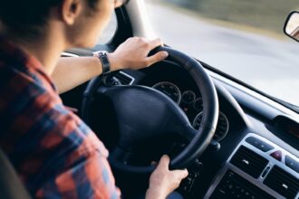 Un hombre sujeta firmemente el volante con las dos manos