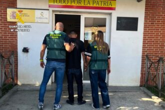 Dos Guardias Civiles de paisano introducen a una persona en el interior de un cuartel.
