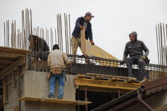 Varioshombres trabajan en un edificio en construcción.