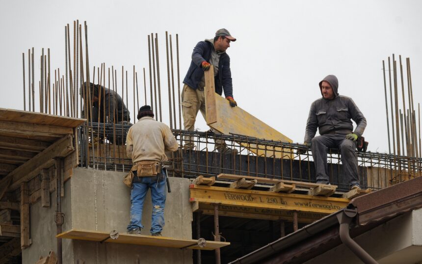 Varioshombres trabajan en un edificio en construcción.