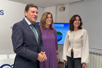 Tres personas sonrien en la sede del PP de Palencia
